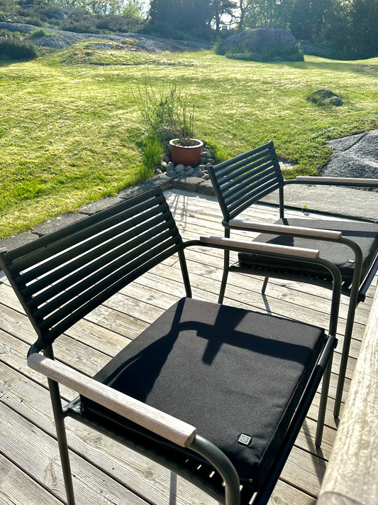 Elektrisk värmedyna på altanstol i en trädgård.